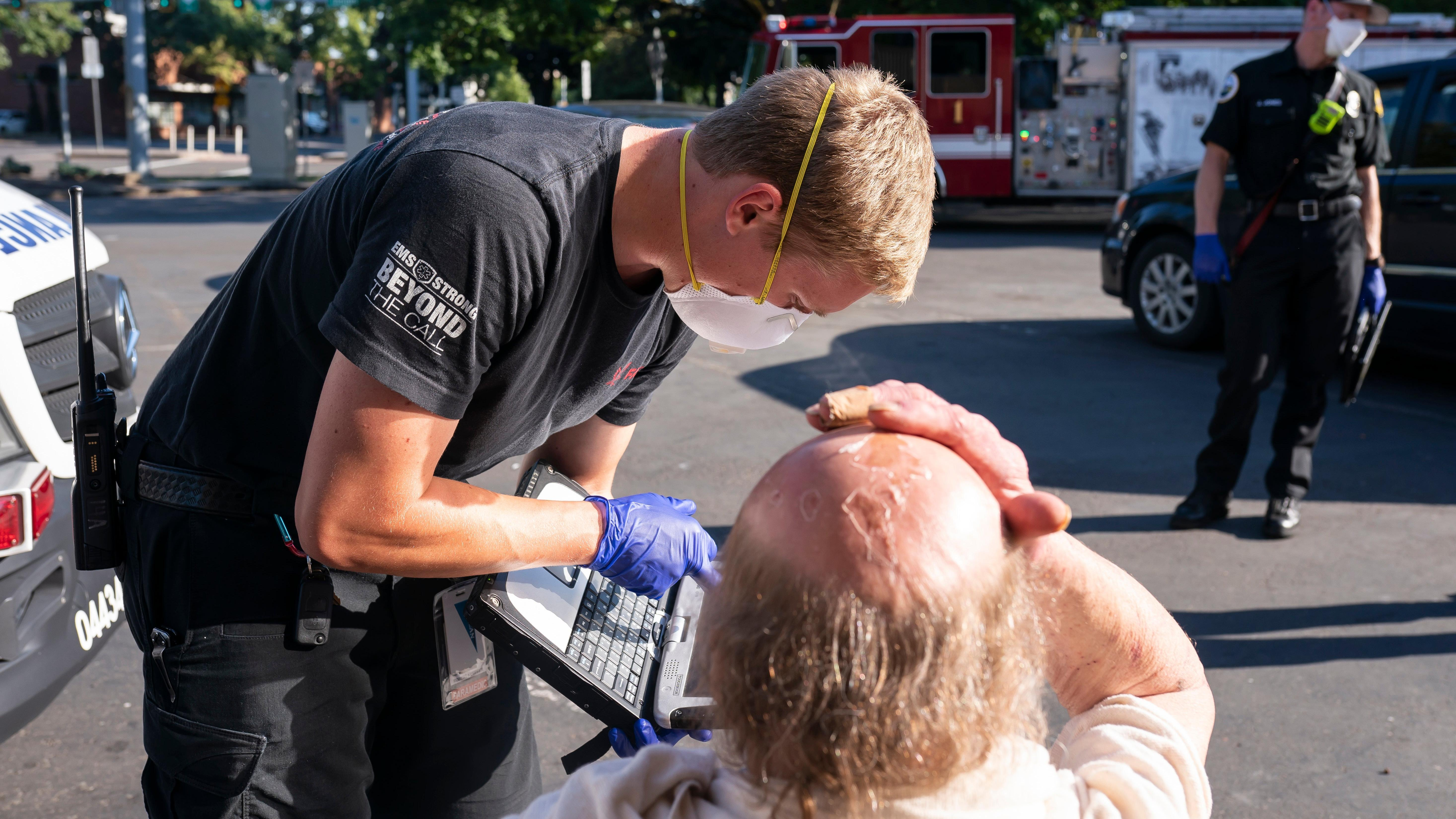 En paramediciner behandler en mand, der oplever varmeeksponering i Salem, Oregon under den nordvestlige hedebølge.
